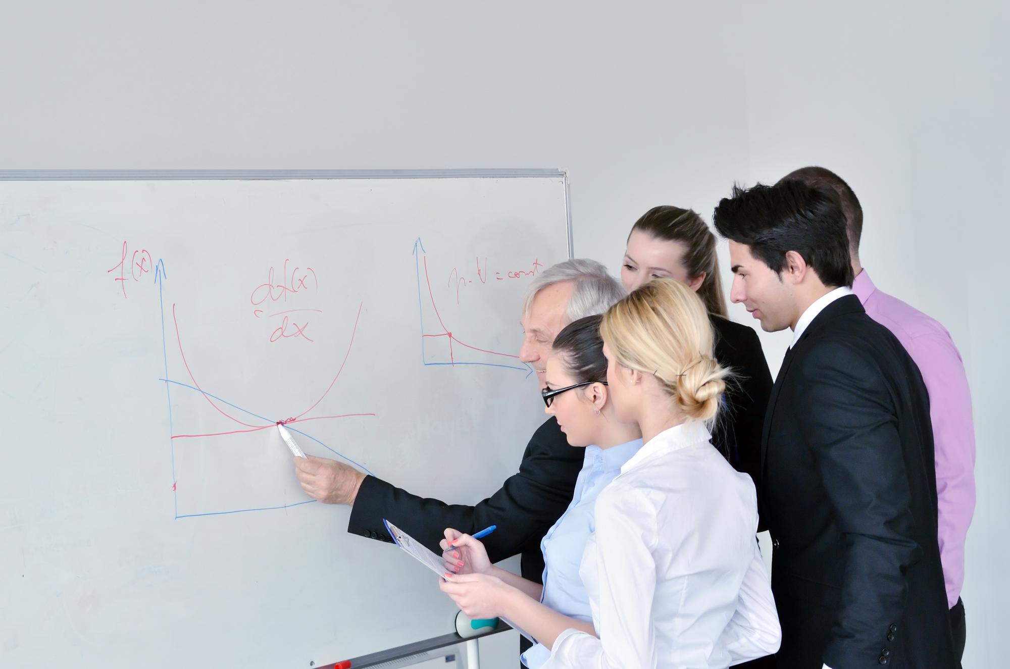 Instructor explaining budget on whiteboard